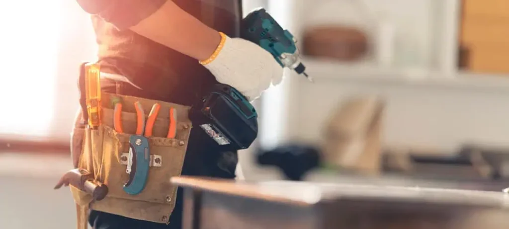 a person with a tool belt holding a drill